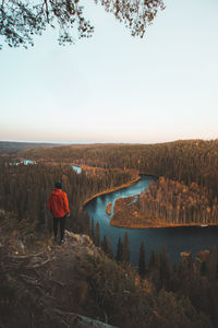 Traveller is looking at bend in kitkajoki river in oulanka  in northern finland during sunset