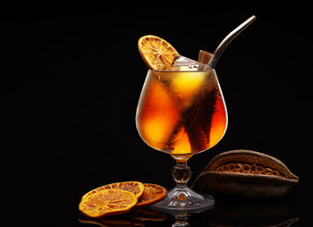 Close-up of wineglass on table against black background