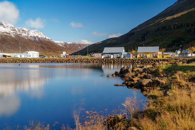 Scenic view of lake by buildings against sky