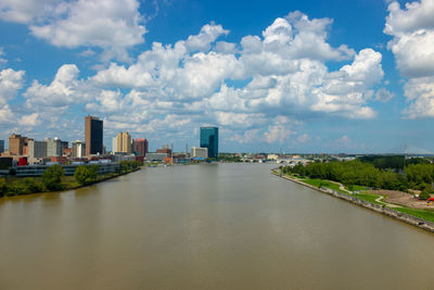 River amidst buildings in city against sky