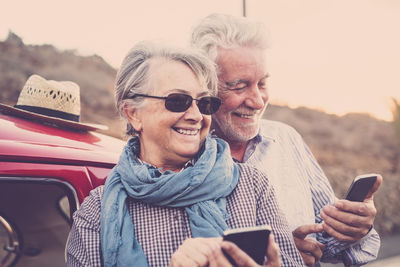 Portrait of happy friends using mobile phone