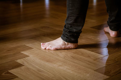 Low section of woman standing on hardwood floor