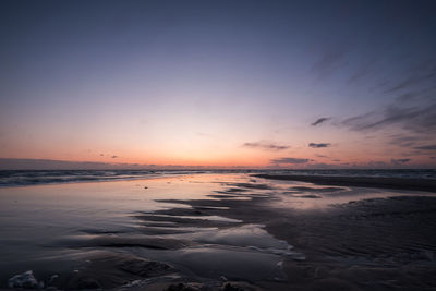 Sunrise at north peak of jutland island in denmark with beach overflowting by waves