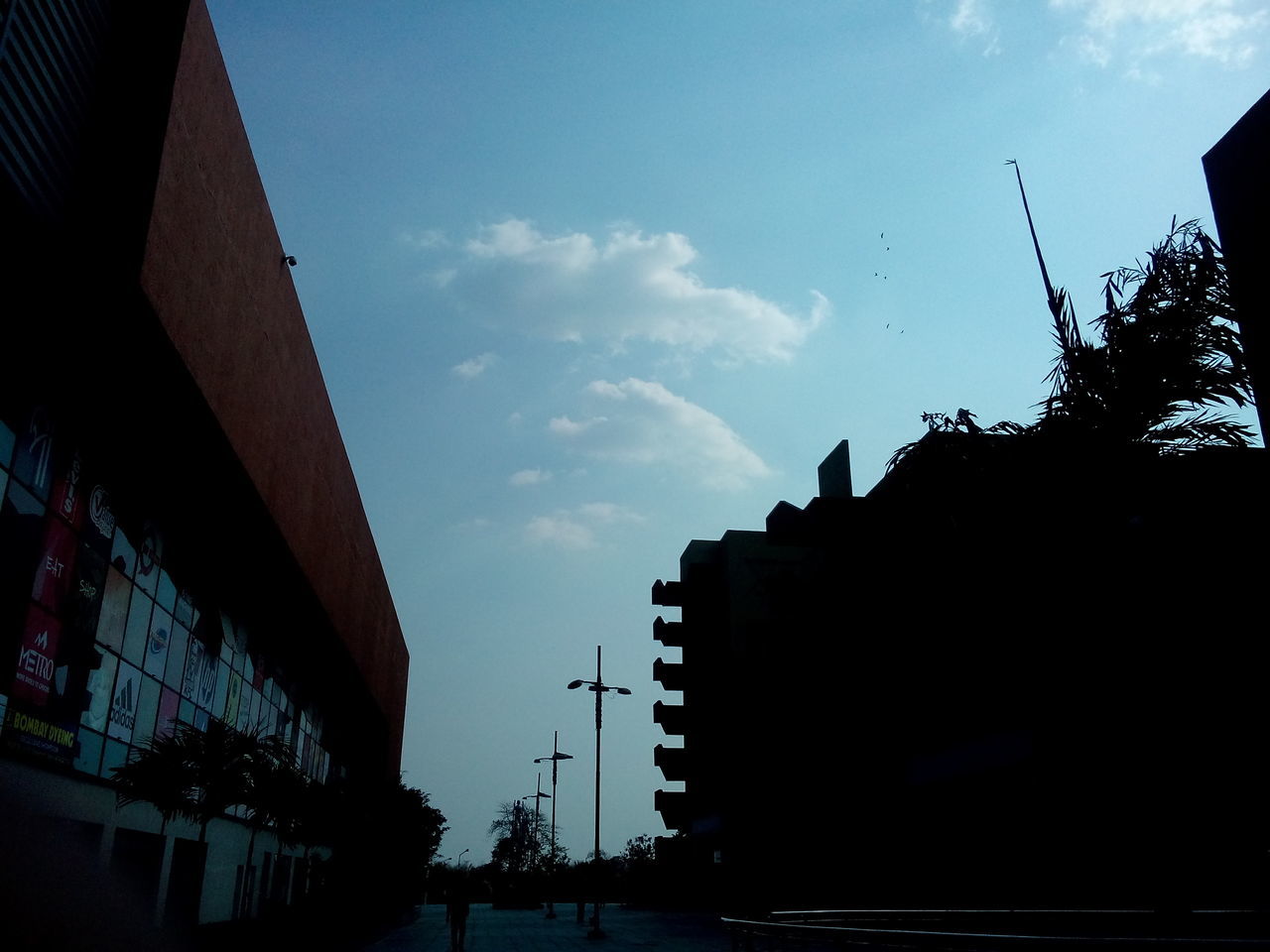 architecture, built structure, building exterior, low angle view, sky, silhouette, cloud - sky, dusk, cloud, transportation, city, outdoors, building, connection, sunset, no people, construction site, cloudy, street light, day