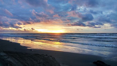 Scenic view of beach against sky during sunset