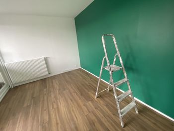 Empty chair on hardwood floor against wall