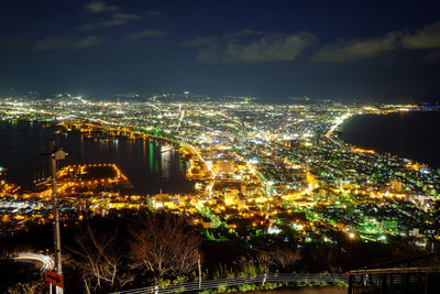 High angle view of illuminated city against sky at night