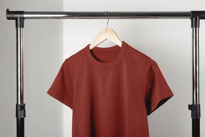 Red clothes hanging on rack against wall