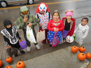 High angle view of girls standing by pumpkin