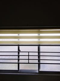 Interior of illuminated railroad station seen through window