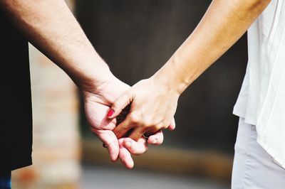 Midsection of couple holding hands