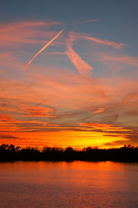 Scenic view of dramatic sky over lake during sunset