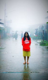 Portrait of woman standing in rain during rainy season