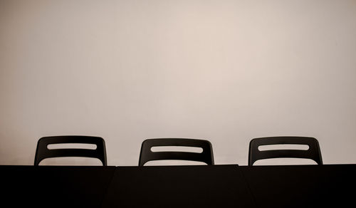 Close-up of empty chairs against wall