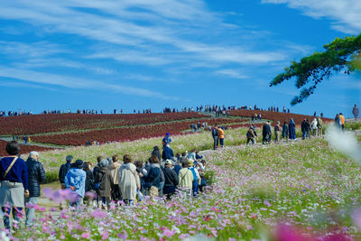 Group of people on field against sky