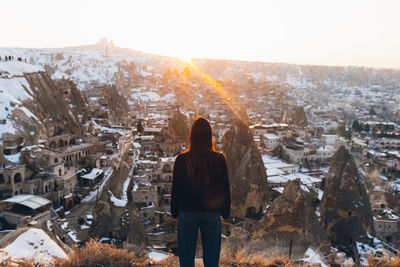 Rear view of woman standing in city during winter