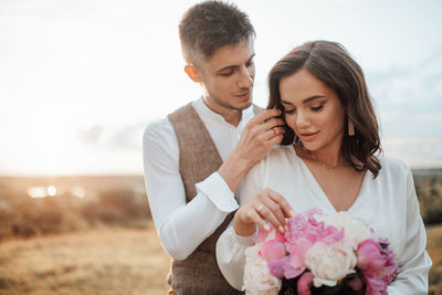 Young couple holding flower bouquet