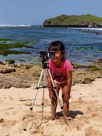 Full length of woman photographing on beach