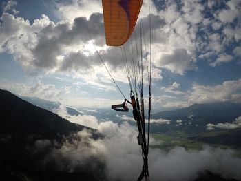 Parachute over landscape against cloudy sky