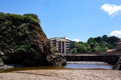 River by buildings against blue sky