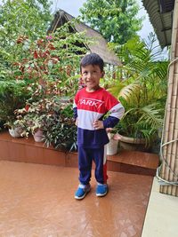 Portrait of boy standing against plants