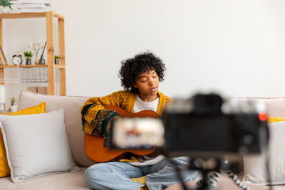 Young woman using phone while sitting at home