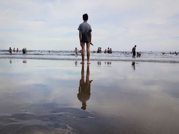 Rear view of people walking on beach