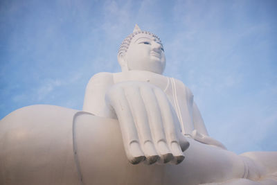 Low angle view of buddha statue against sky
