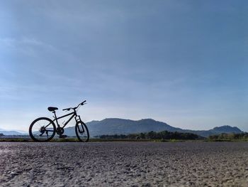 Bicycle parked on land against sky