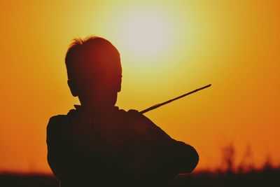 Silhouette of man playing at sunset