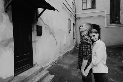 Man and woman standing on street against building in city