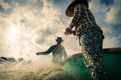 People by water against sky