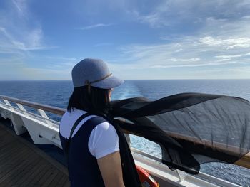 Rear view of man looking at sea against sky