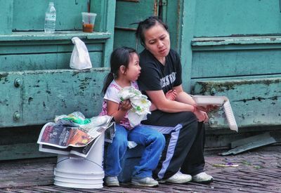 Mother and daughter sitting outdoors