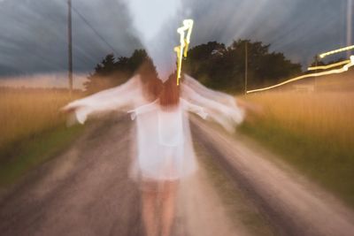 Digital composite image of woman on road amidst trees