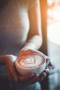 Midsection of woman holding coffee cup