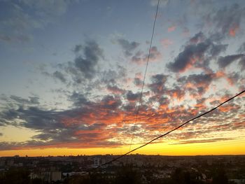 Low angle view of silhouette cables against sky during sunset