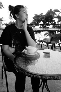 Young woman with coffee cup on table