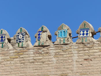 Low angle view of landscape against blue sky