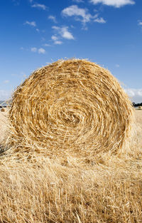 Hay bales on field against sky