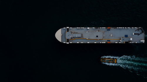 Aerial view of illuminated ship in sea at night