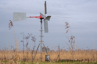 Windmill on field against sky