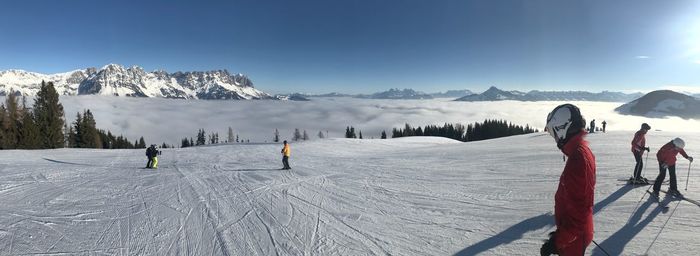 People skiing on snowcapped mountain against sky