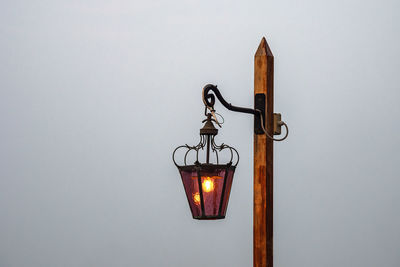 Low angle view of illuminated lamp hanging on wall