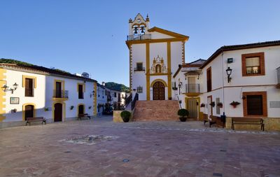 Street amidst buildings in city against clear sky