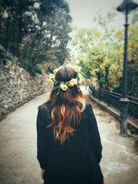 Rear view of woman standing against trees