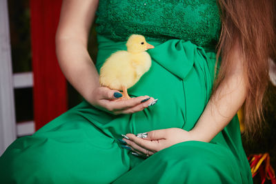 Midsection of woman holding bird