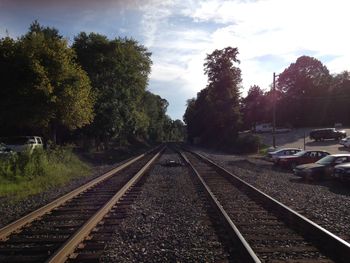 Railroad tracks amidst trees against sky