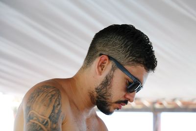 Close-up of shirtless man wearing sunglasses