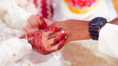 Cropped hands of couple during wedding ceremony